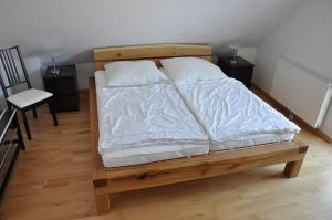 Bett mit weißer Bettwäsche und Kissen in einem Zimmer in der Unterkunft Ferienwohnungen im Veenhuus in Kellenhusen