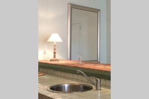 a sink in a bathroom with a large mirror at La Pierre Levée in Montigny-sur-Loing