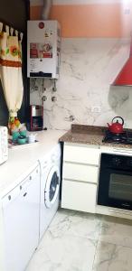 een witte keuken met een fornuis en een wasmachine bij MDQ 4to20 in Mar del Plata