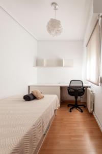 a bedroom with a bed and a desk and a chair at Apartamentos El Llombo in Ontinyent