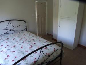 a bedroom with a bed with a floral comforter at firtrees in Selby