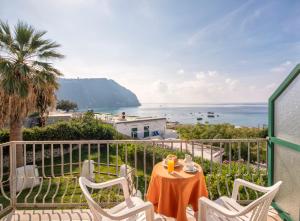 un tavolo e sedie su un balcone con vista sull'oceano di Hotel Citara a Ischia