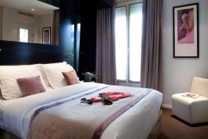 a hotel room with a large bed with shoes on it at Marceau Champs-Elysées in Paris