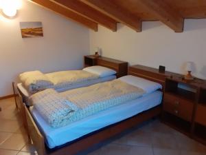 a bedroom with two beds and a dresser at Appartamenti Rumo in Rumo