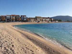 a beach with a group of houses and the ocean at Apartmani Adam in Primošten