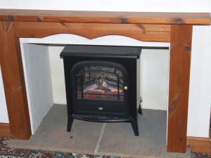 a fireplace in a living room with a stove at firtrees in Selby