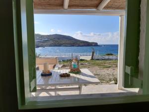 a table with a view of the ocean from a window at Sunset Studios & Rooms in Antiparos