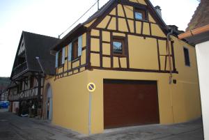 a building with a large garage in a street at maison d en haut in Wintzenheim
