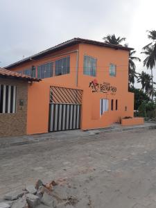 un bâtiment orange avec un panneau sur son côté dans l'établissement Pousada Beira Rio, à Santo Amaro