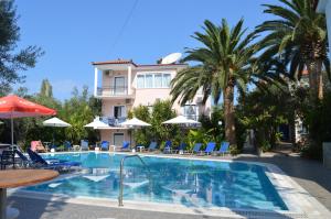 a hotel with a swimming pool and palm trees at Anaxos Gardens in Anaxos
