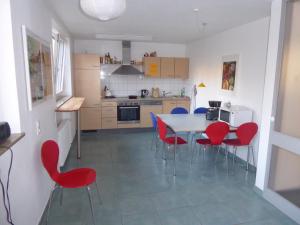 a kitchen with a table and red chairs in it at Topp Apartments in Tübingen