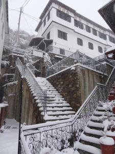 a snow covered staircase in front of a building at Charis Guesthouse in Makrinítsa