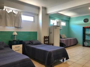1 dormitorio con 2 camas y paredes verdes en Departamento Belgrano 7 en Salta