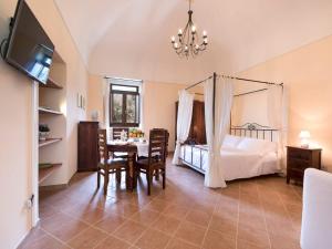 1 dormitorio con 1 cama, mesa y sillas en Casale Le Noci, en Vico Equense
