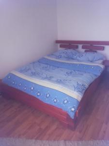 a bed in a room with a blue blanket on it at Simona in Topliţa