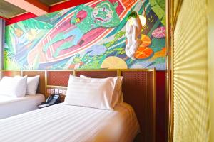 Cette chambre comprend deux lits et un tableau mural. dans l'établissement 4 Monkeys Hotel, à Bangkok