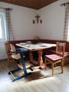 uma mesa e cadeiras num quarto com uma cruz na parede em Aignerbauer Mittersill em Mittersill