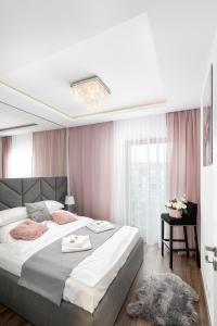 1 dormitorio con 1 cama grande y cortinas rosas en Crystal Luxury Apartments Rakowicka 20H en Cracovia