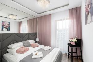 1 dormitorio con 1 cama grande y cortinas rosas en Crystal Luxury Apartments Rakowicka 20H, en Cracovia