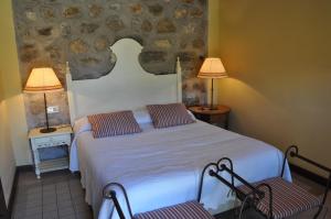 um quarto com uma cama com 2 cadeiras e 2 candeeiros em La Casa del tío Americano em Albarracín