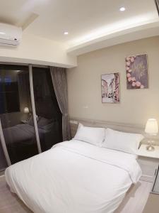 a bedroom with a large white bed in it at 日出逢甲 in Taichung