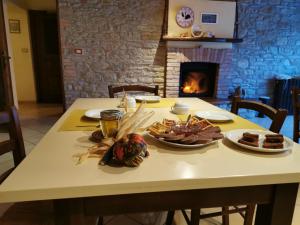 a table with plates of food and a fireplace at Agriturismo Mondo in Bubbio