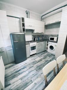 a kitchen with white appliances and a table and chairs at Розкішна квартира. Подобово. Центр! in Ternopilʼ