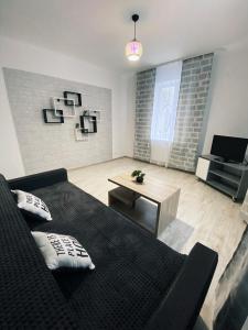 a living room with a black bed and a table at Розкішна квартира. Подобово. Центр! in Ternopilʼ +9 photos