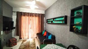 a room with a couch and a tv and a window at Condominio Severos Mar in Ubatuba