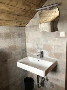 a white sink in a bathroom with a wooden ceiling at Stubihuettn in Sonnenalpe Nassfeld