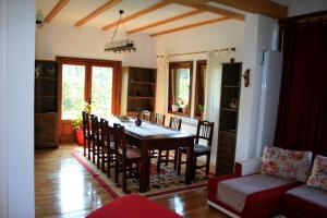 uma sala de jantar com mesa e cadeiras em Albinuta Guesthouse em Ozun