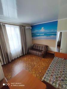 a living room filled with furniture and a window at Arbuz Guest House in Zaliznyy Port