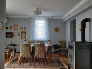 a dining room with a table and chairs and a fireplace at Holiday Home Ilidza Rose in Sarajevo +25 photos