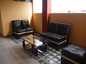 duas cadeiras de couro e uma mesa numa sala de espera em Hotel Suite Juliaca em Juliaca