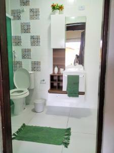 La salle de bains est pourvue de toilettes et d'un lavabo. dans l'établissement Suítes Praia Martin de Sa, à Caraguatatuba