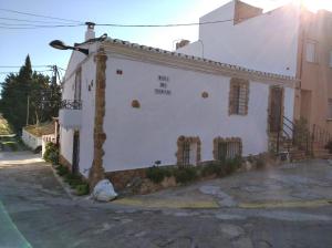 um edifício branco com um sinal na lateral em Casa Rural COMPLEX MASIA DEL TREMENDO y Agroturismo em Camarles