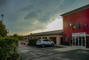 a car parked in a parking lot in front of a building at Hotel Motel Giglio in Viadana