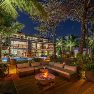 a living room with a couch and a fire pit at Hotel Spa Nau Royal in Camburi