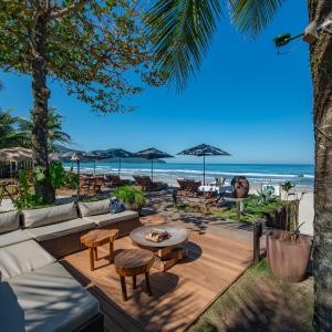 a patio with a table and chairs and the beach at Hotel Spa Nau Royal in Camburi