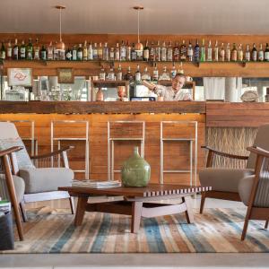 a man standing behind a bar in a restaurant at Hotel Spa Nau Royal in Camburi