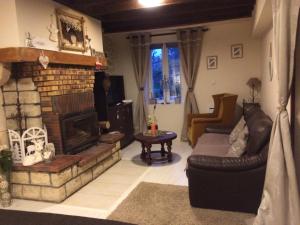 a living room with a couch and a fireplace at Maison familiale Centre France in Meunet-sur-Vatan