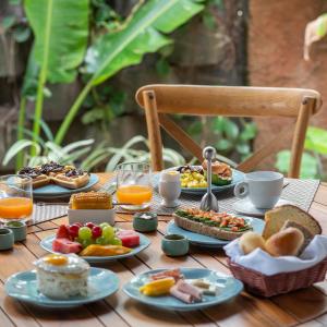 a table topped with plates of breakfast foods and orange juice at Hotel Spa Nau Royal in Camburi