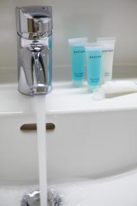 a counter with two cups and a faucet at Bastion Hotel Heerlen in Heerlen