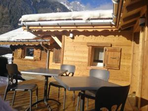 two tables and chairs on a deck in front of a cabin at Le Bivouac in Chamonix