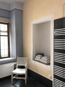La salle de bains est pourvue d'un miroir, d'une chaise et de serviettes. dans l'établissement Wolke 33, à Annaberg-Buchholz