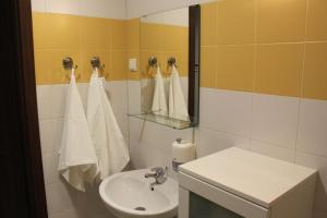 a bathroom with a sink and a mirror and towels at Apartament nad jeziorem Sukiel z własną plażą in Olsztyn