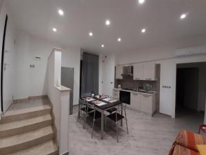 a kitchen and living room with a table and chairs at Casa Aci GioJa in Aci Catena