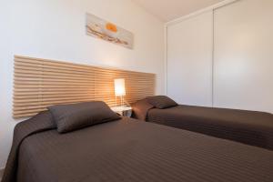 コルバーラにあるRésidence Speloncaのベッドルーム1室(ベッド2台、ランプ、窓付)