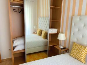 a bedroom with a mirror next to a bed at Duarte Houses T2 - com vista mar in Nazaré