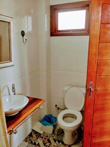 a bathroom with a toilet and a sink at Casa alquiler en Bombas Bombinhas in Bombas